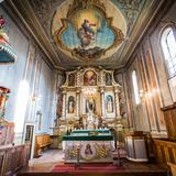 Wnętrze drewnianego kościoła. Prezbiterium z polichromiami, barokowym ołtarzem i amboną.