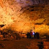Grupa zwiedzająca Jaskinię Nietoperzową w Jerzmanowicach. Znajdują się w przestronnej, oświetlonej komorze.