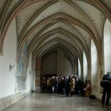 Pomieszczenie klasztorne, freski na sklepieniu żebrowym, białe ściany. Na środku turyści.
