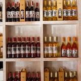 Zdjęcie ukazuje pułki pełne butelek z winem pochodzącym z winnicy kresy. W butelkach widoczne wino czerwone, różowe oraz białe.