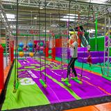 Dzieci bawiące się na hali wyposażonej w wewnętrzny park linowy i park trampolin