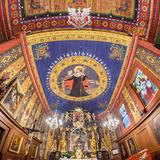 Strop kościoła z malowidłami przedstawiającymi postaci, kwiaty i wzory geometryczne. Na drewnianych ścianach obrazy.