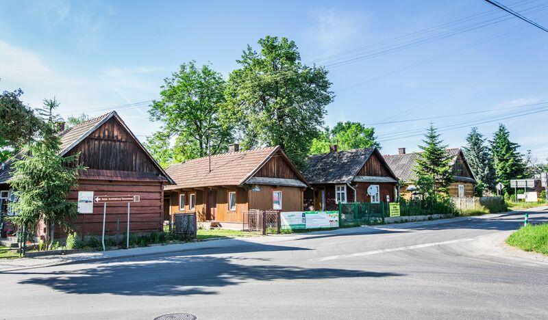 Drewniana zabudowa we wsi Mokrzyska, chaty stojące wzdłuż drogi.