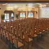 Duża sala konferencyjno-balowa z ekranem na ścianie i kilkudziesięcioma krzesłami w układzie teatralnym.