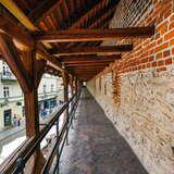Fragment murów obronnych Krakowa, gdzie znajduje się ścieżka z balustradą oraz drewniany daszek.