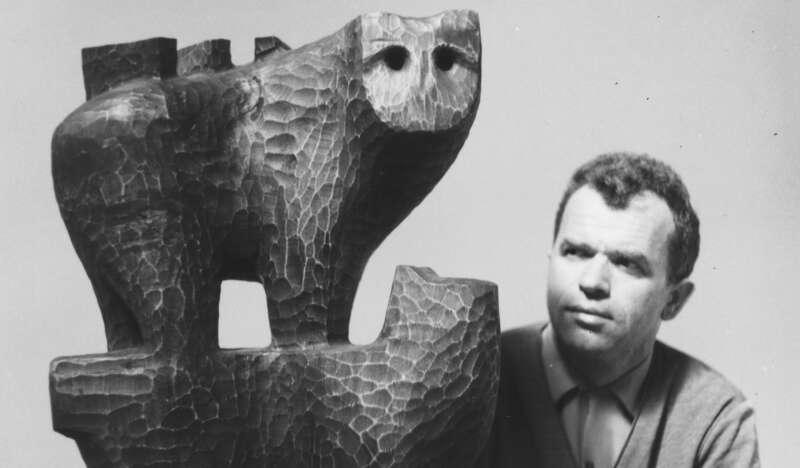 mężczyzna Grzegorz Pecuch wpatrzony w swoją rzeźbę przedstawiającą niedźwiedzia