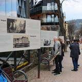 ludzie stojący przed tablicami opisującymi miasta Sopot i Zakopane