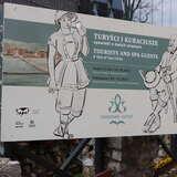 zbliżenie na tablicę informującą o wystawie Turyści i Kuracjusze opowieść o dwóch miastach